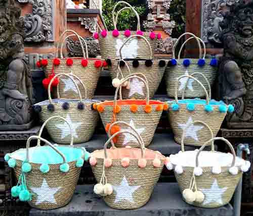 Divers paniers tressés décorés de pompons en vente à l'export pour grossistes par agent sourcing à Bali en Indonésie. 